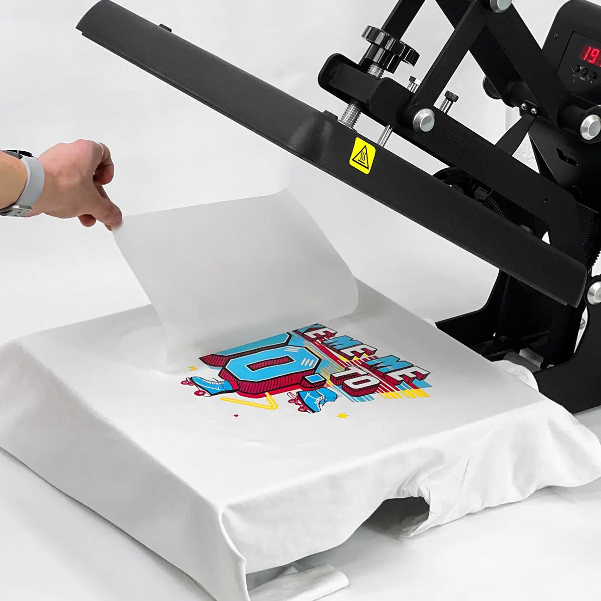 Heat press machine applying colorful DTF transfer onto white t-shirt - DTF Print Online