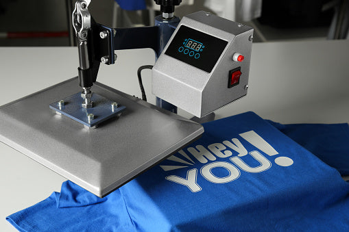 Heat press machine pressing DTF transfer onto blue t-shirt - DTF Print Online