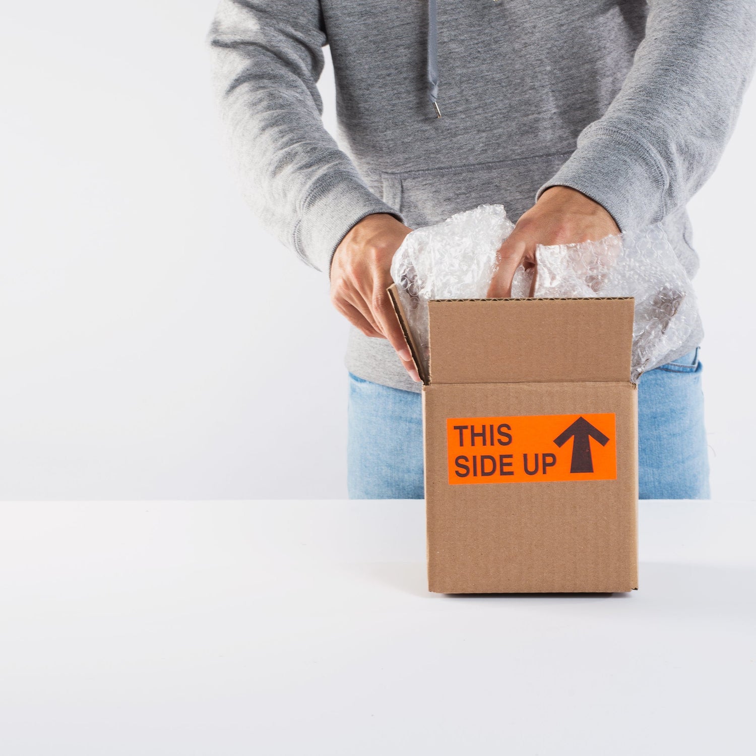 Person packing a cardboard shipping box - fast UK delivery - DTF Print Online